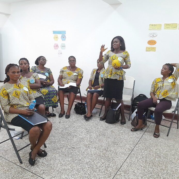 Facilitator standing and guiding a seated group through an exercise